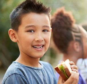 a happy kid with a sandwich