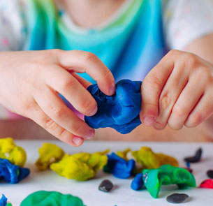 a child playing with clay