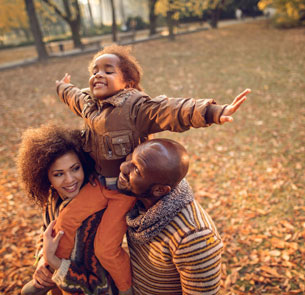 a young family in autumn leaves