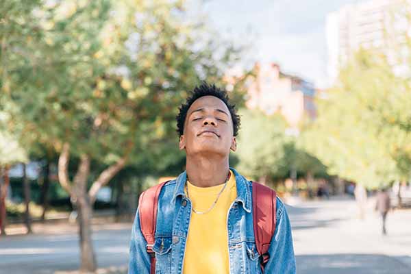 Relaxed boy breathes fresh air in a park on an autumn day