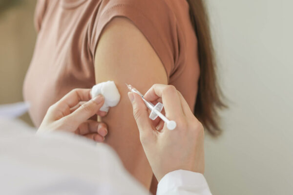 Closeup of a woman receiving an allergy shot in a doctor's office.