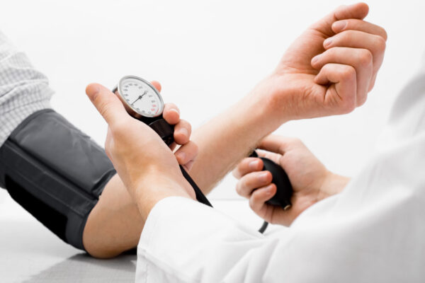 Closeup of a healthcare provider monitoring a patient's blood pressure